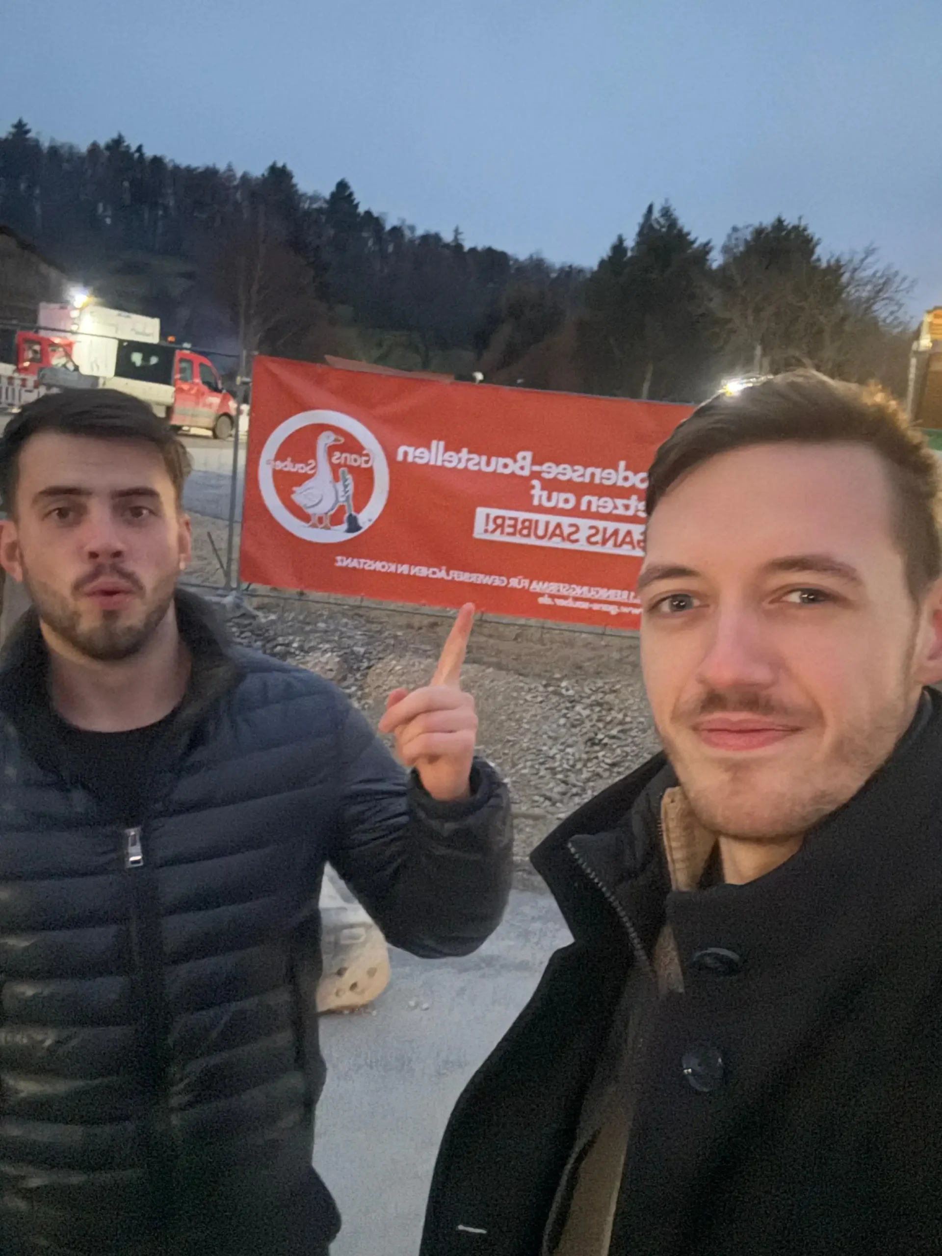 Vor einem Schild der Partnerfirma Gans Sauber